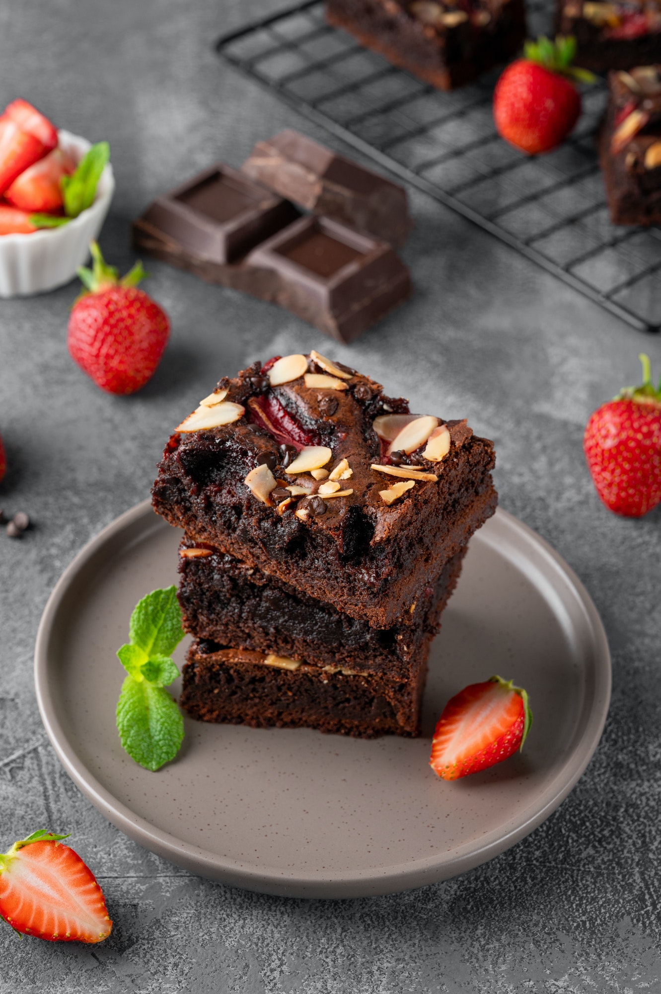 Chocolate brownie pieces with nuts, strawberry and ice cream on a plate. Selective focus.